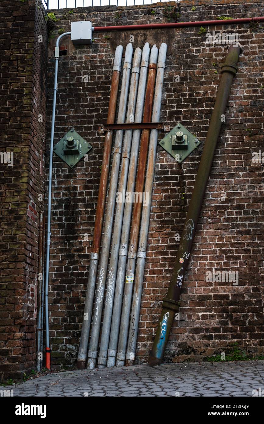 Pipes on brick walls near the historic steps from the lower level of Factors Walk alley to Bay Street in Savannah, Georgia, United States. Stock Photo