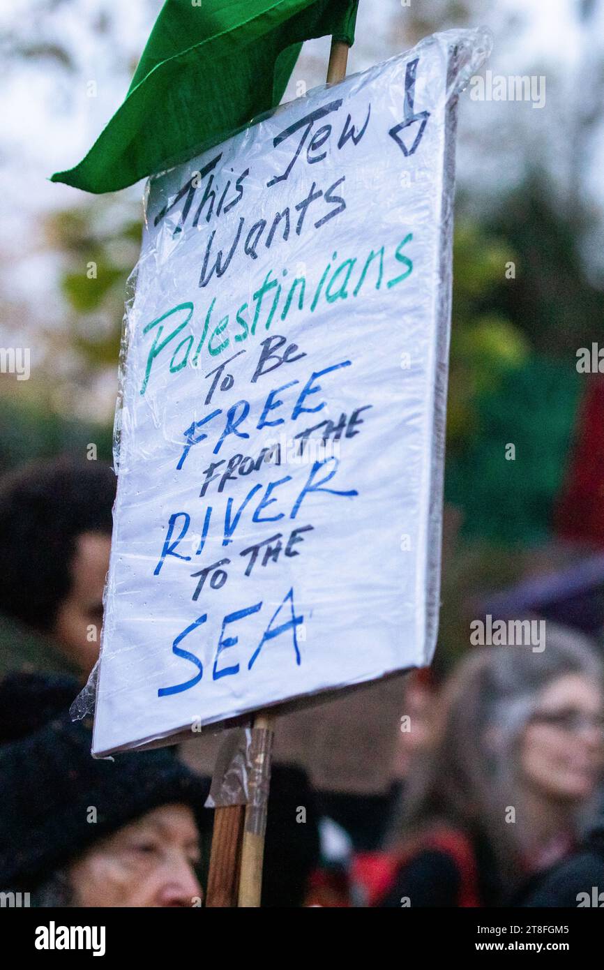 London, UK. 19th November, 2023. A sign is pictured among members of ...