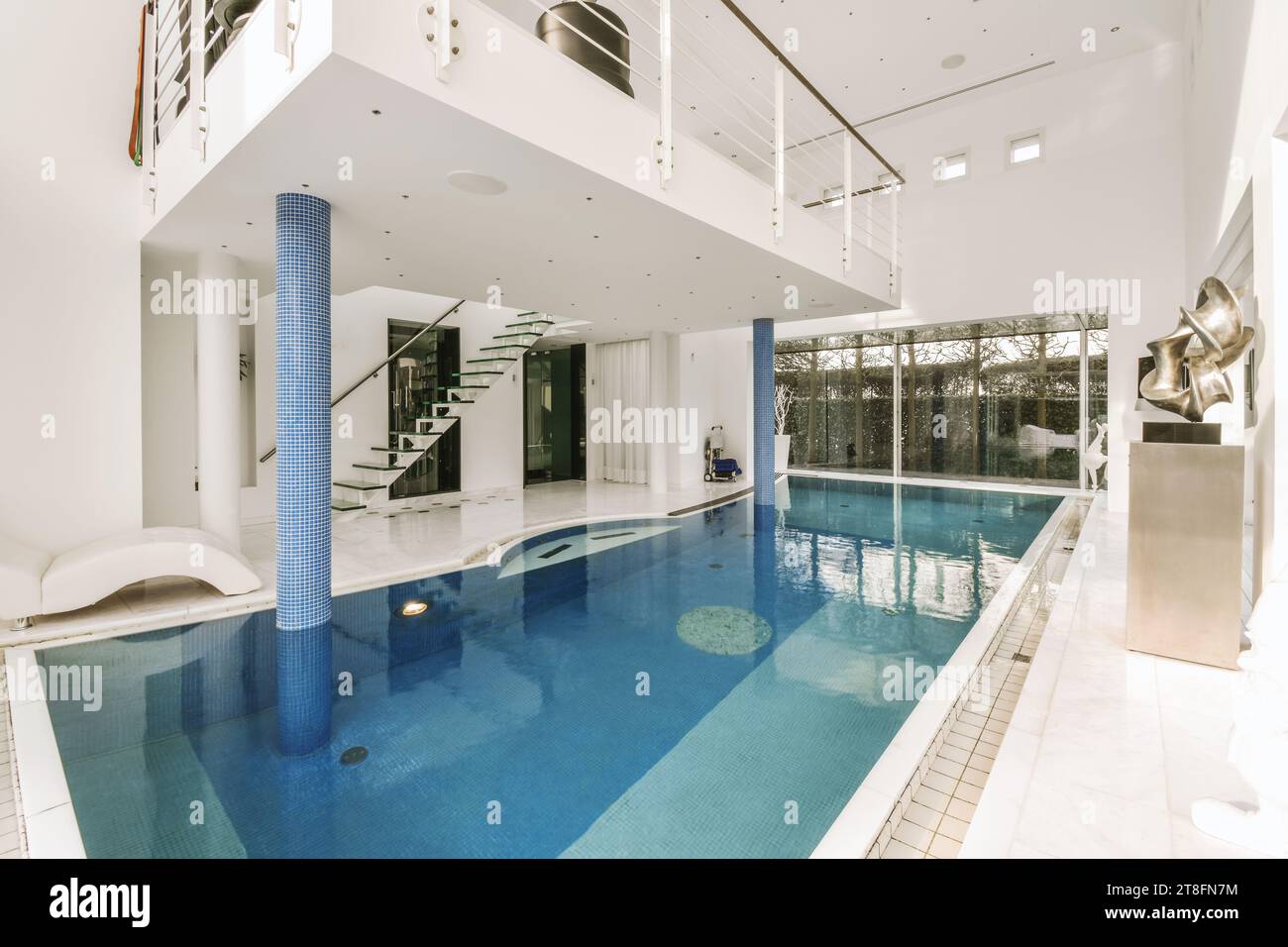 View of Swimming pool with large window and staircase leading to upper floor in ...