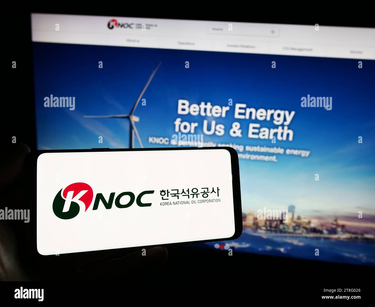 Person holding smartphone with logo of petroleum company Korea National