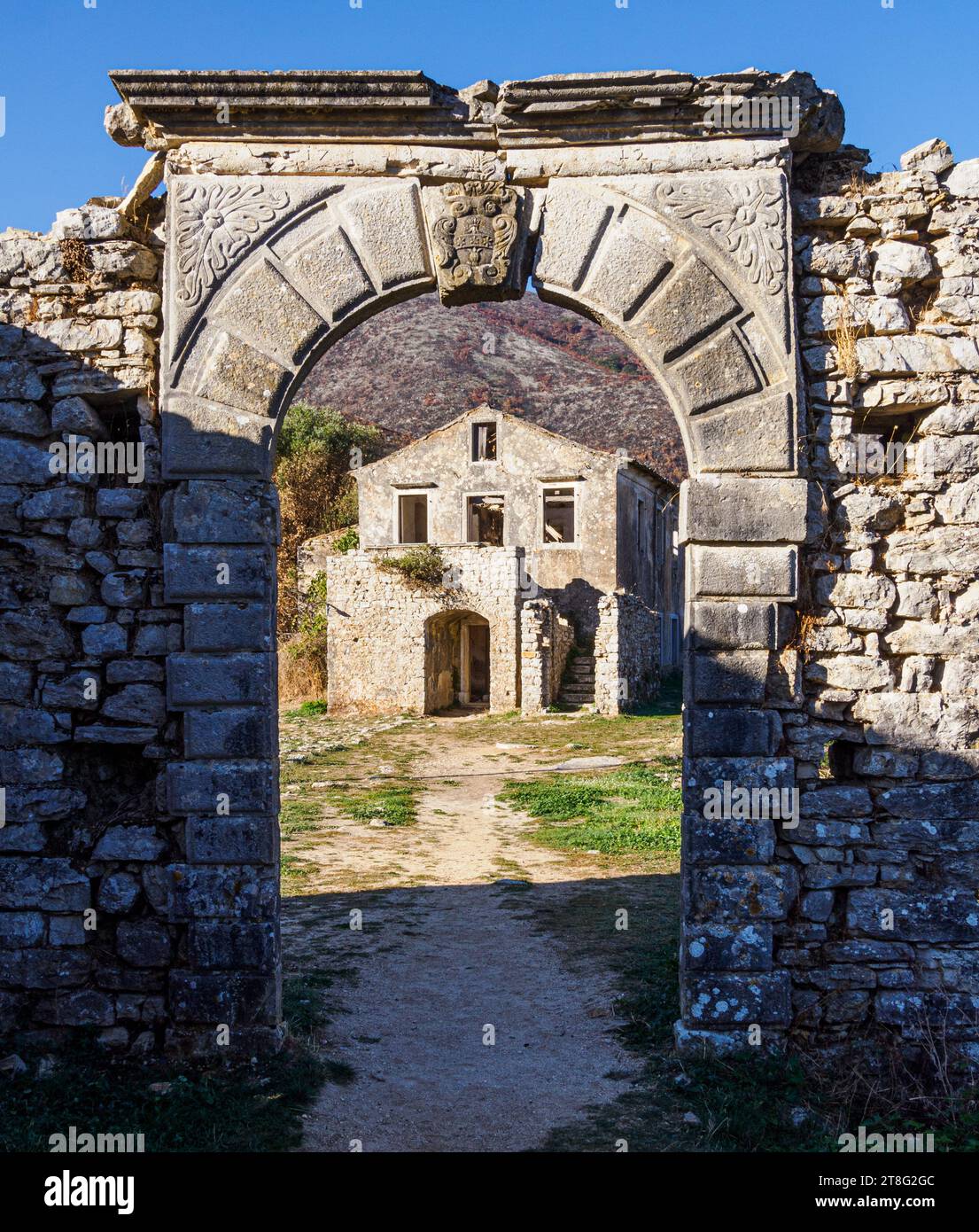 Ruined schoolhouse and arch in the partially abandoned village of Old Perithia (Palea Perithea) on the high slopes of Mt Pandokratoras in Corfu Greece Stock Photo