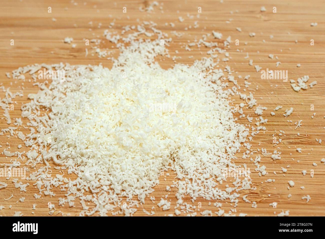 Grated Parmesan Cheese on a Cutting Board. Stock Photo