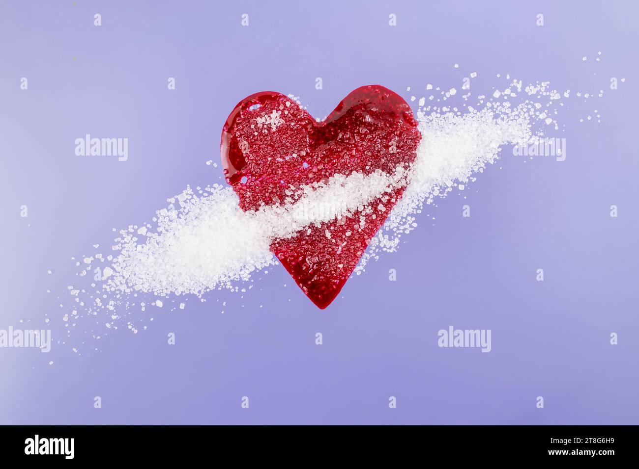 Red blood splatter in form of a heart mixed with sugar crystals on