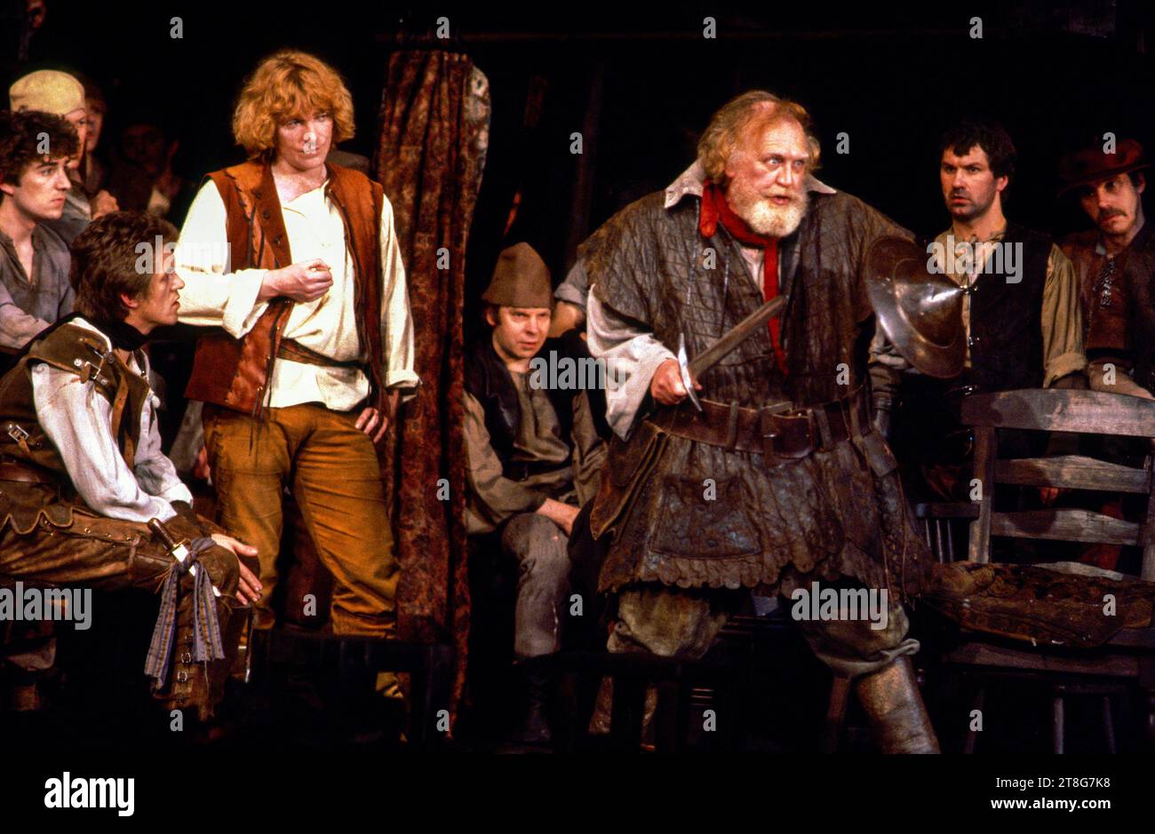 Eastcheap, the Boar's Head Tavern, Falstaff re-enacts his battle  - left: Miles Anderson (Ned Point), Gerard Murphy (Prince Hal)  right: Joss Ackland (Sir John Falstaff) in HENRY IV part 1 by Shakespeare at the Royal Shakespeare Company (RSC), Barbican Theatre, London EC2  07/05/1982  music: Guy Woolfenden  design: John Napier  lighting: David Hersey  fights: Malcolm Ranson  director: Trevor Nunn Stock Photo
