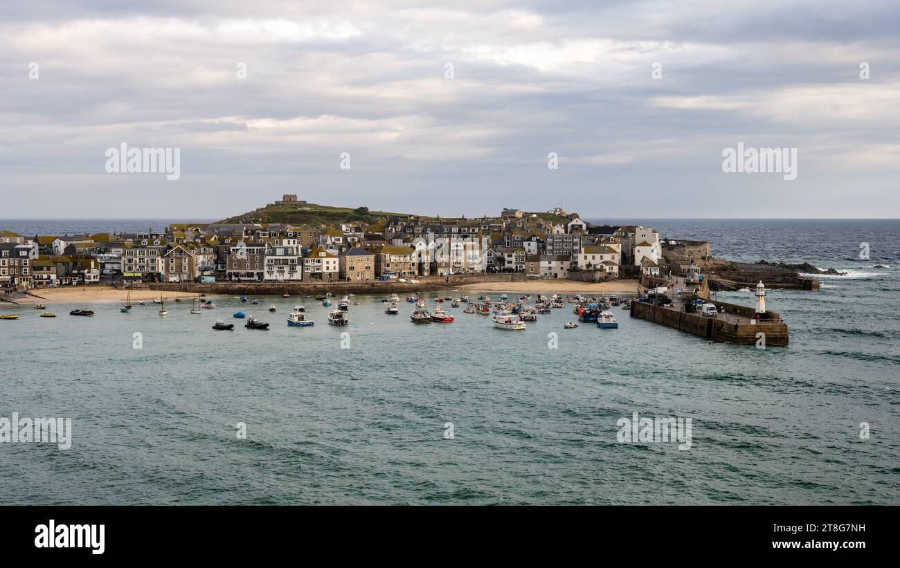 Morning light shines on St Ives harbour and The Island on the Atlantic coast of Cornwall. Stock Photo