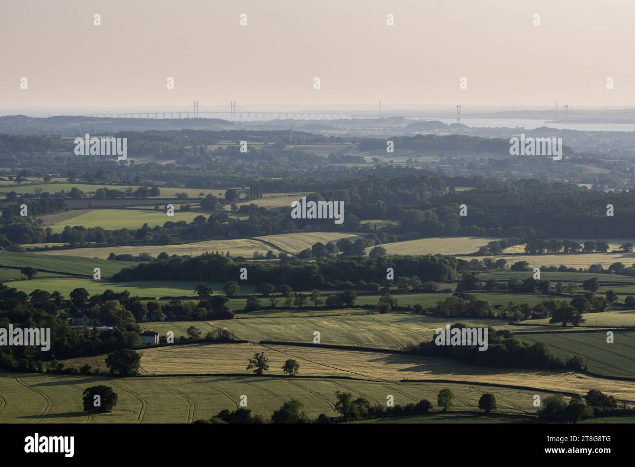 A patchwork of farmland fields and woodland fills the landscape of the Severn Valley as viewed from the Cotswolds Edge in Gloucestershire. Stock Photo