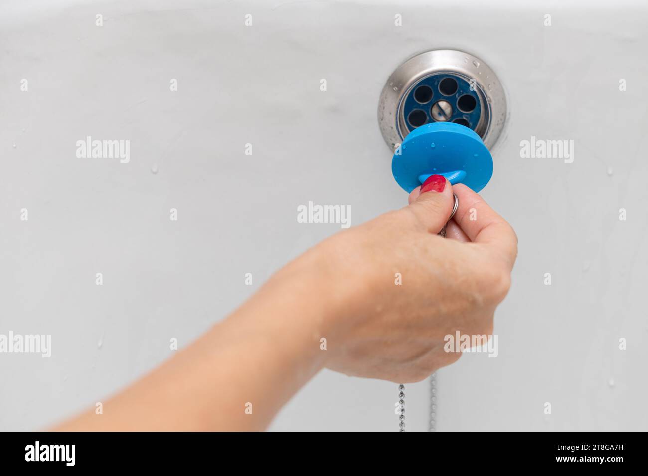 woman's hand closes the drain hole in the bathroom. drain hole in the