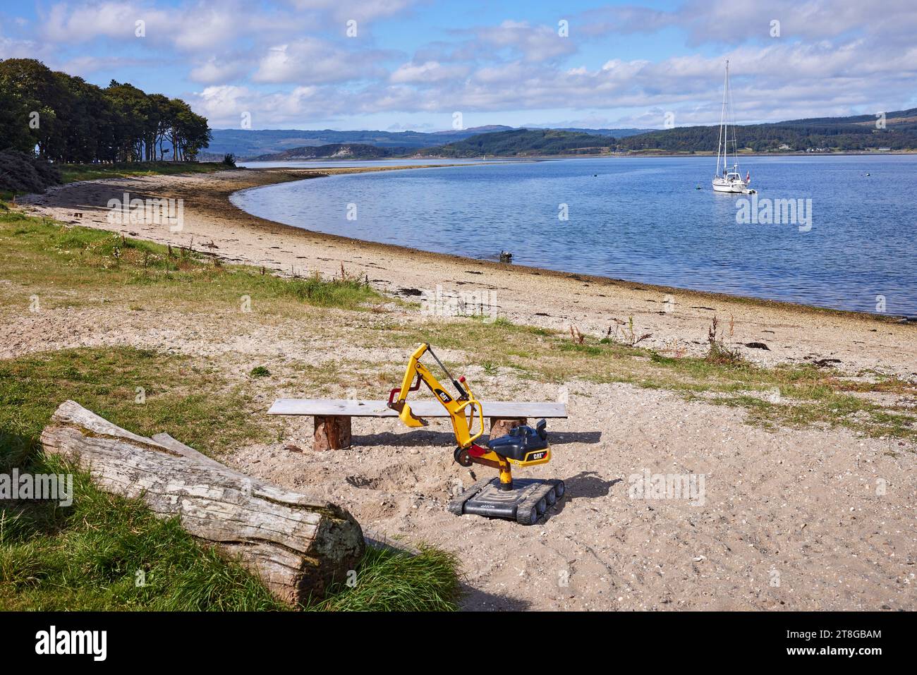 Toy CAT digger on the beach at Otter Ferry. Argyll Stock Photo
