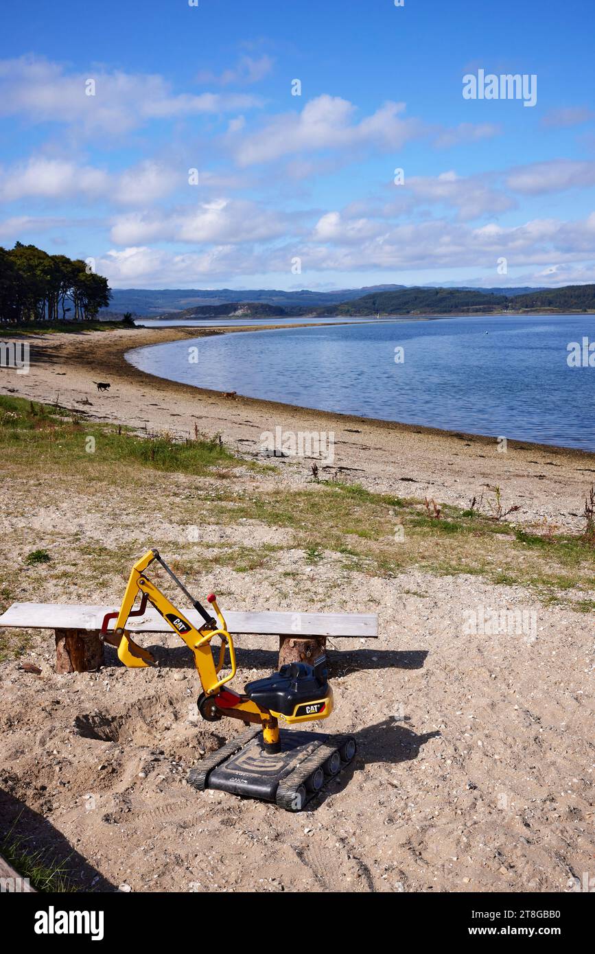 Toy CAT digger on the beach at Otter Ferry. Argyll Stock Photo