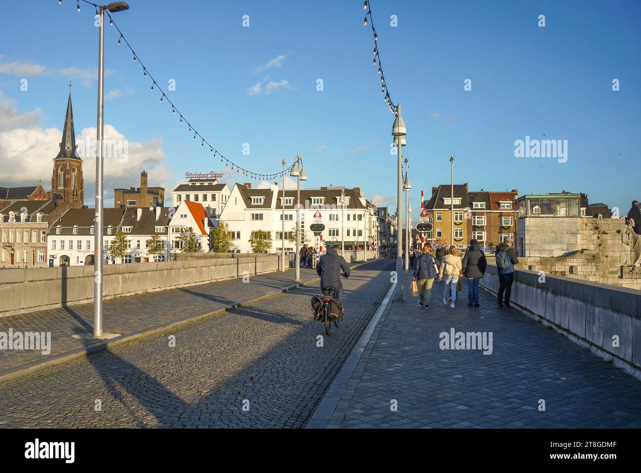 Pedestrians and cyclers crossing the Sint Servaasbrug, St. Servatius Bridge, across the river Meuse in Maastricht, Limburg, Netherlands. Stock Photo