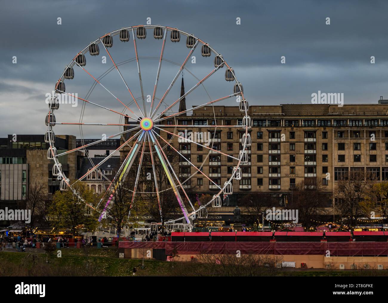 Edinburgh, Scotland, UK, 20th November 2023. The lights of Christmas decorations, Christmas market and the big ferris wheel funfair ride in Princes Street Garden are an attraction in the dusk light. Credit: Sally  Anderson/Alamy Live News Stock Photo