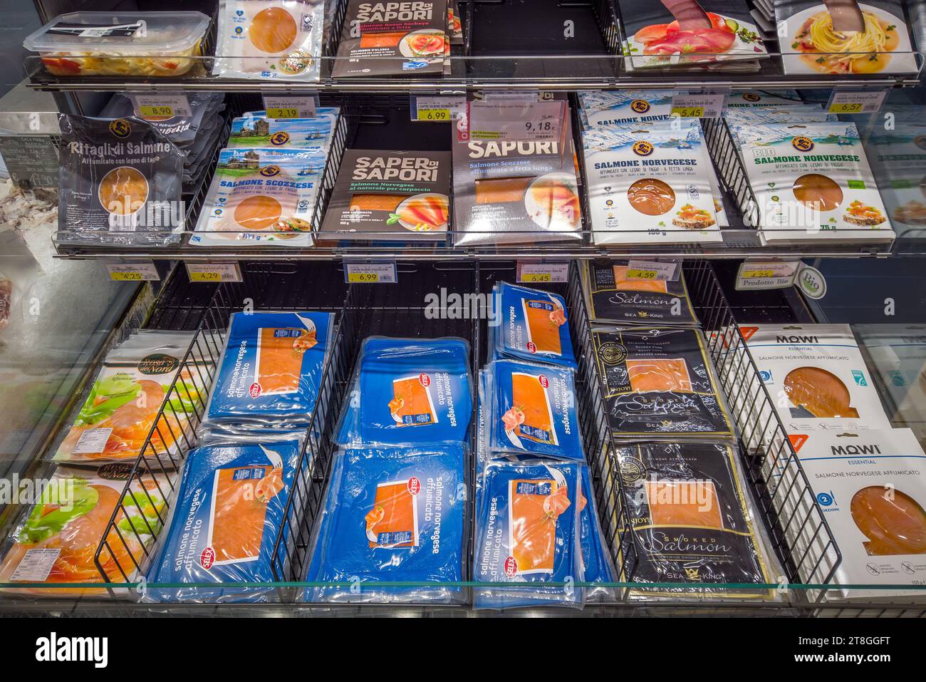 Italy - November 20, 2023: Smoked salmon of various origins in packages of various types and brands displayed for sale in the refrigerated counter of Stock Photo