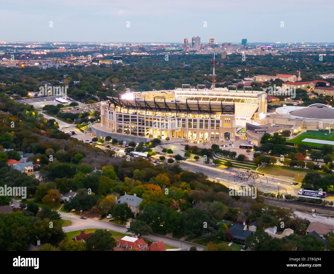 Fort Worth, TX - November 10, 2023: Amon G. Carter Stadium on the Texas Christian University Campus at night wtih Fort Worth skyline in the background Stock Photo