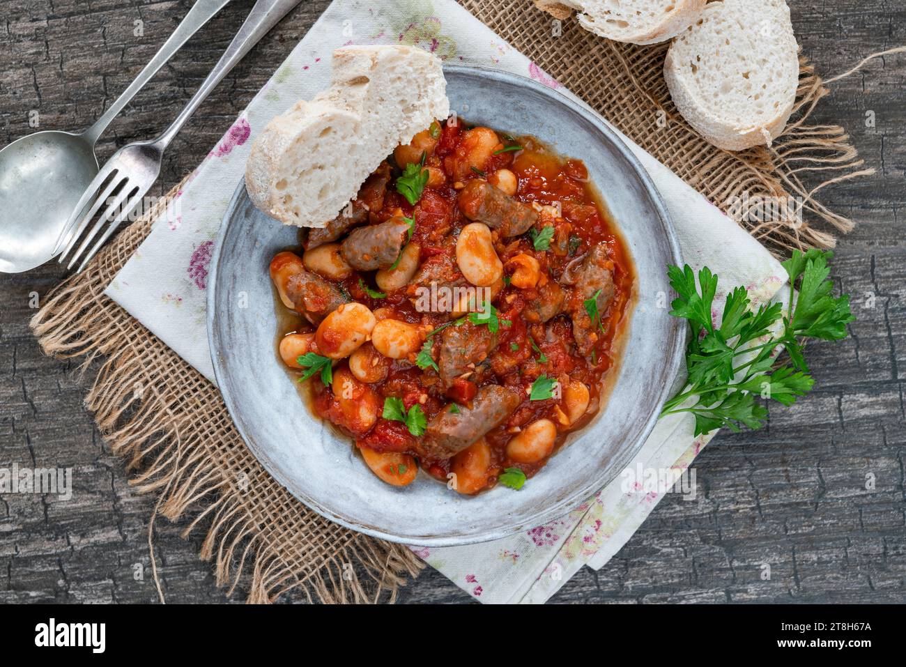 Beef chipolatas and bean casserole with crusty bread Stock Photo - Alamy
