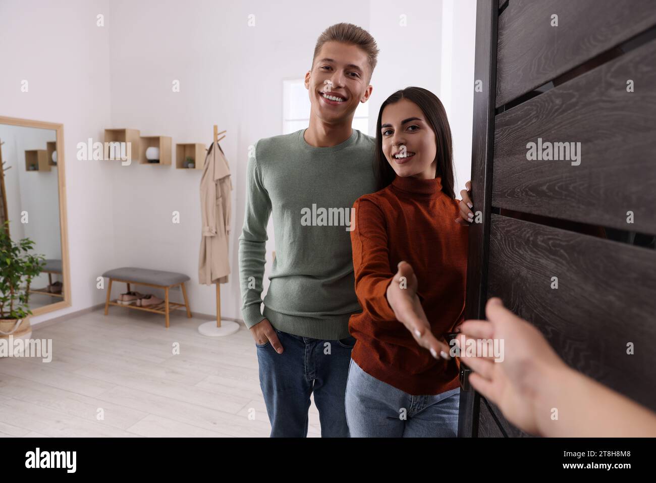 Couple greeting guest door hi-res stock photography and images - Alamy