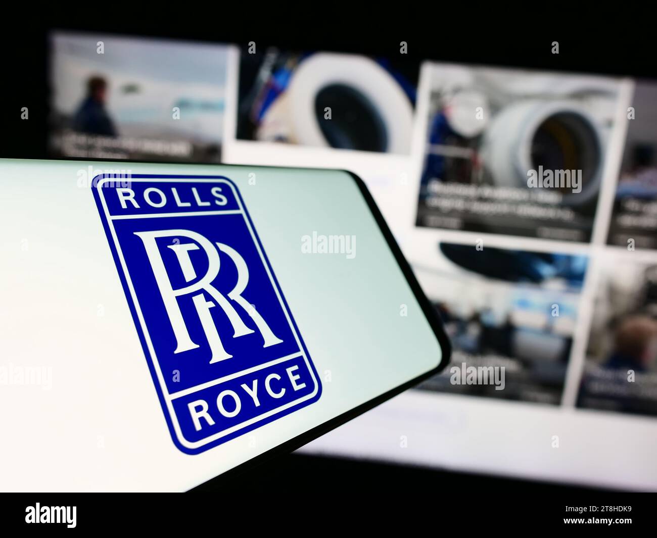 Smartphone with logo of British aerospace company Rolls-Royce Holdings plc in front of business website. Focus on center-left of phone display. Stock Photo