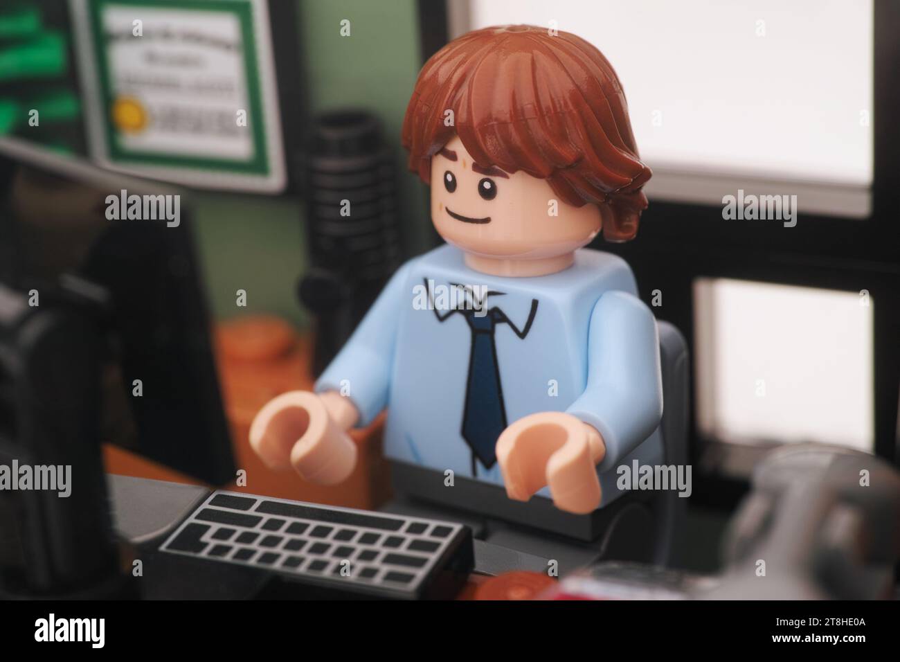 Tambov, Russian Federation - November 01, 2023 A Lego businessman minifigure sitting and working behind a computer in an office. Close up. Stock Photo