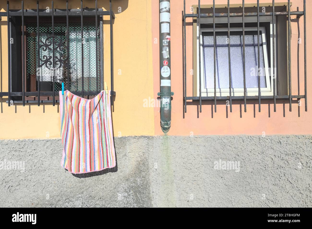 Facade  of a building with windows and a cloth hanging from one of them Stock Photo