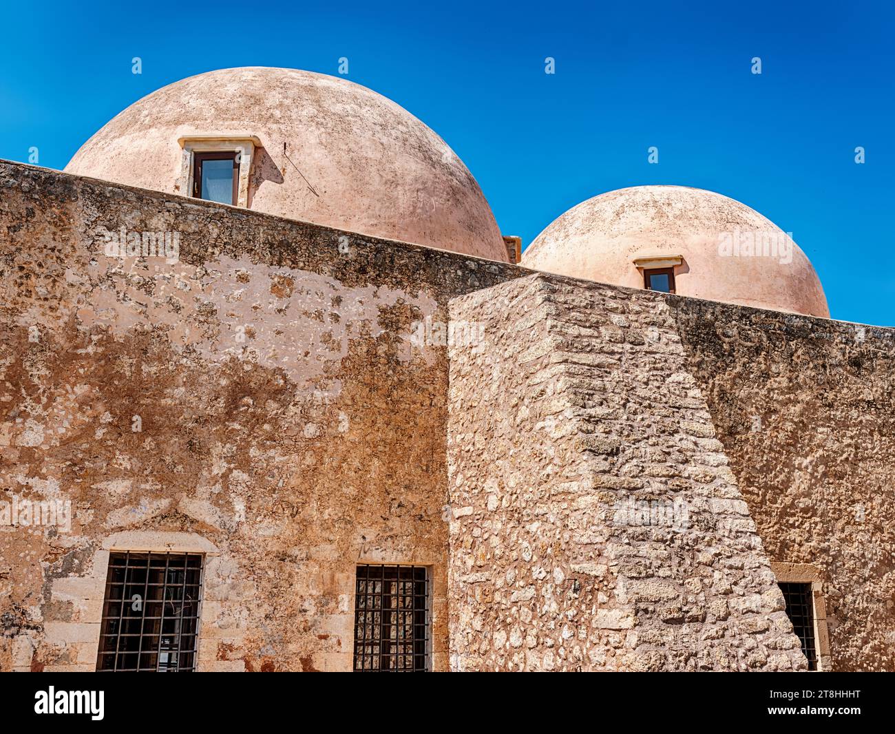 Two domes on the top of the Neratze mosque in Rethymno, Crete catch the sunlight on a sunny day. Stock Photo