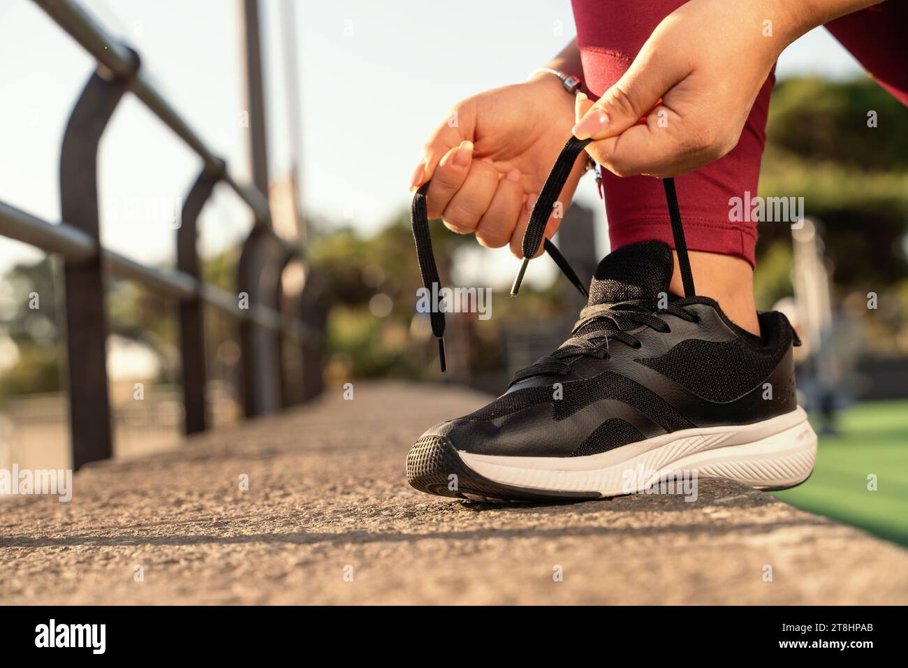 Closeup of a woman tying her running shoes, poised to start her