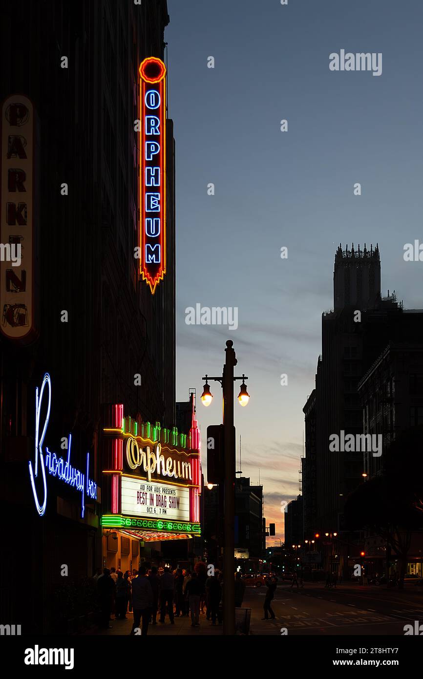 An urban nighttime scene featuring a city street with glowing neon signs Stock Photo