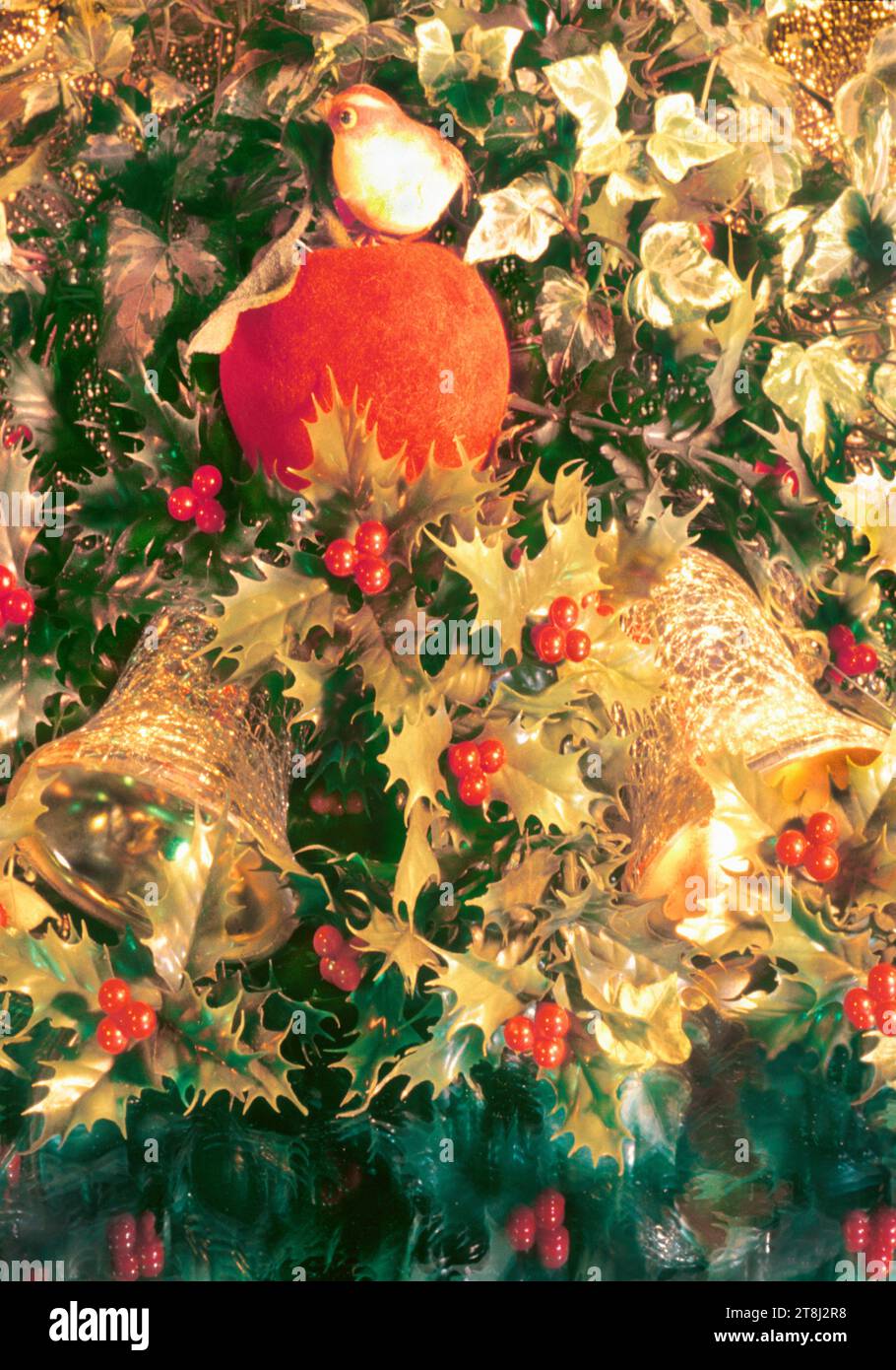 Christmas holiday decorations.Christian festive holiday decor  Mistletoe, berries, gold bells bird and an apple. Stock Photo
