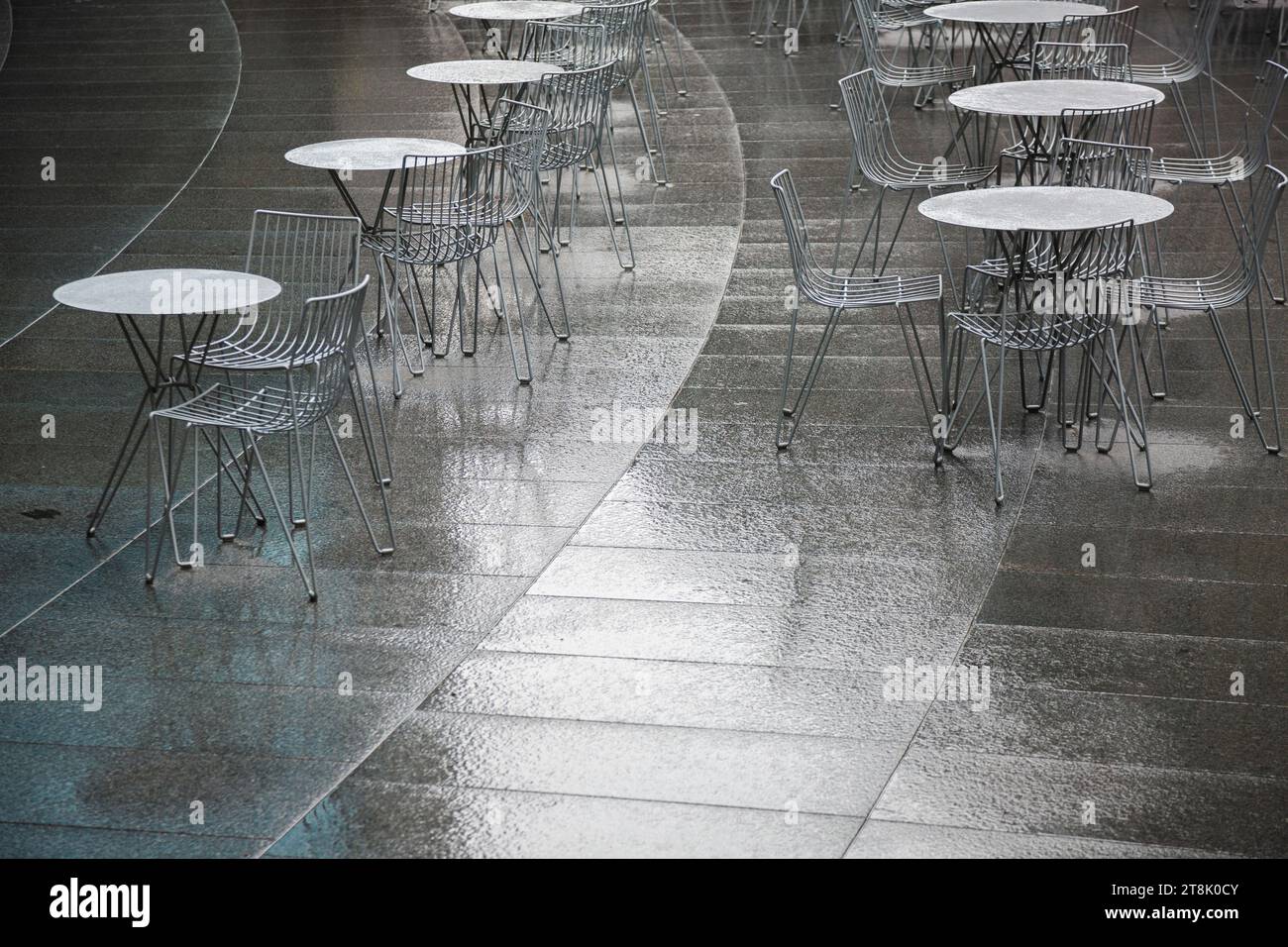 Outdoor café tables and chairs on rainy day Stock Photo