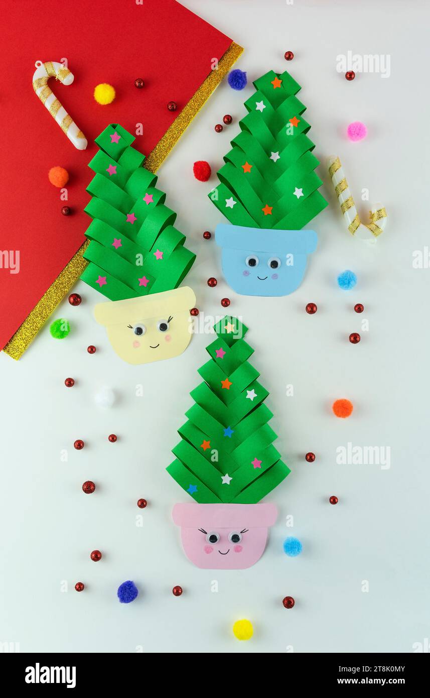 Handmade creative funny Christmas trees with eyes made from paper on colorful background Stock Photo