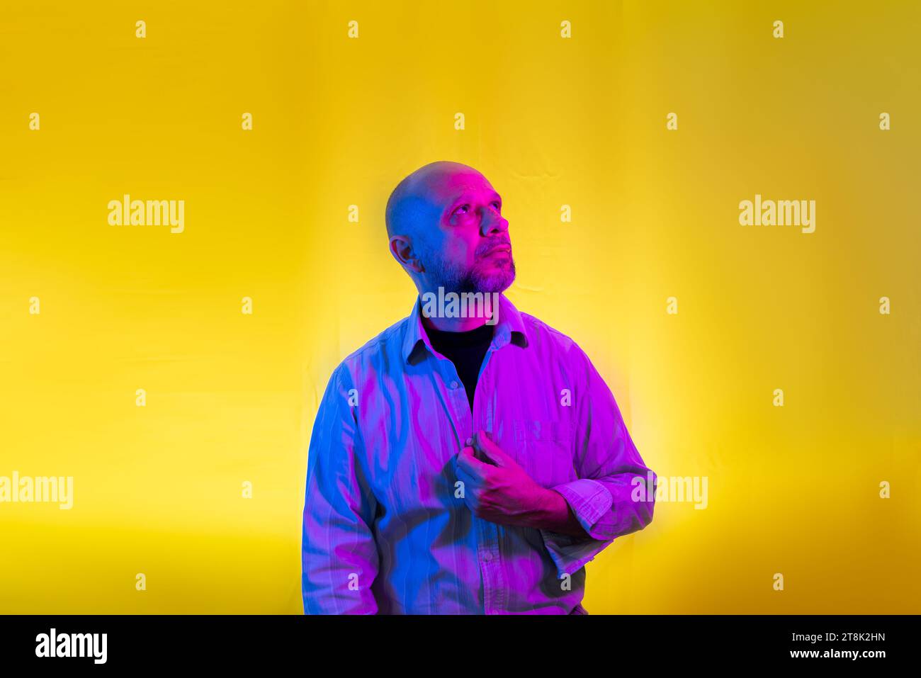 Bald, bearded man in dress shirt. Isolated on yellow background. Stock Photo