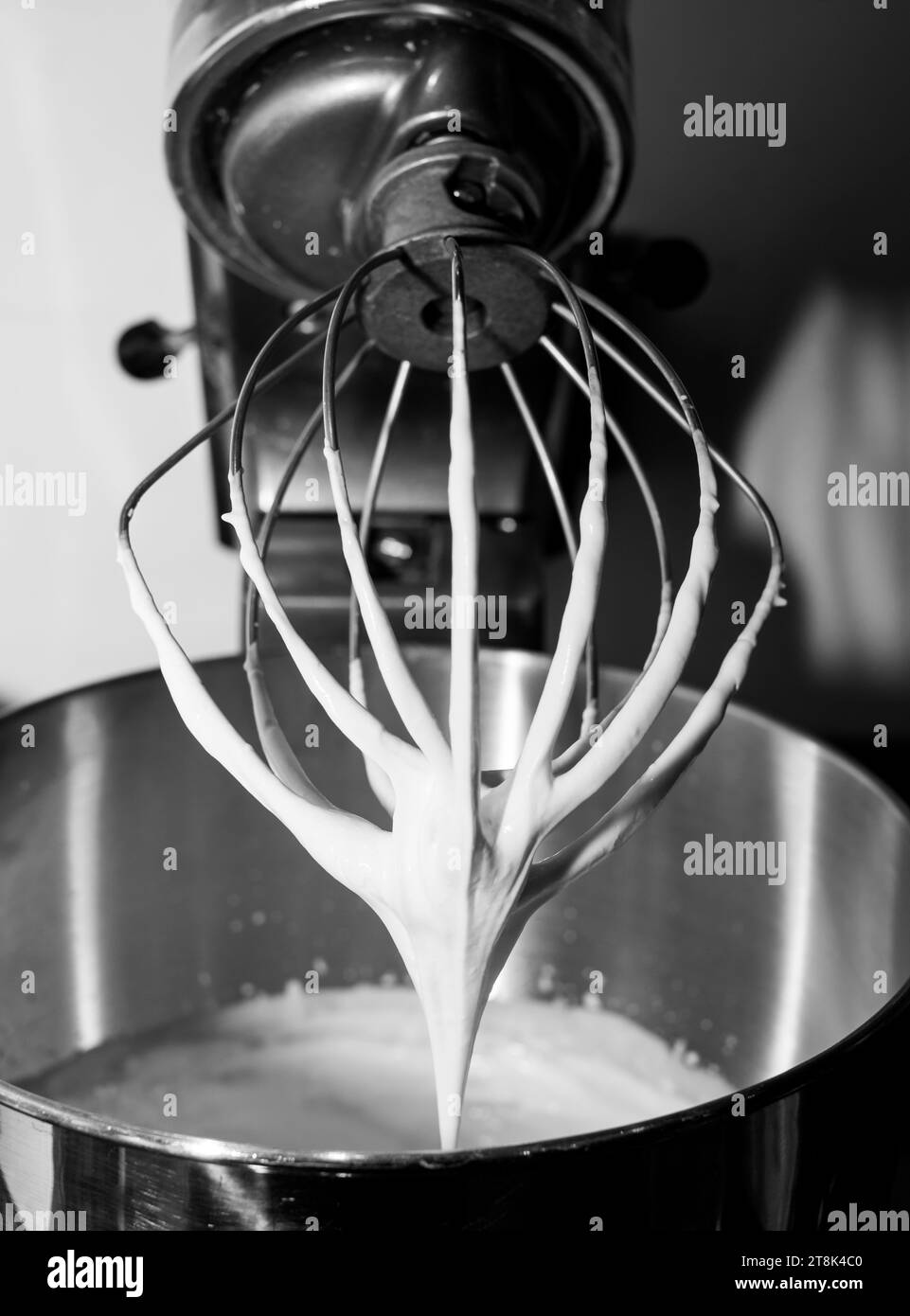 Whipped double cream in a bowl beaten in an electric mixer Stock Photo