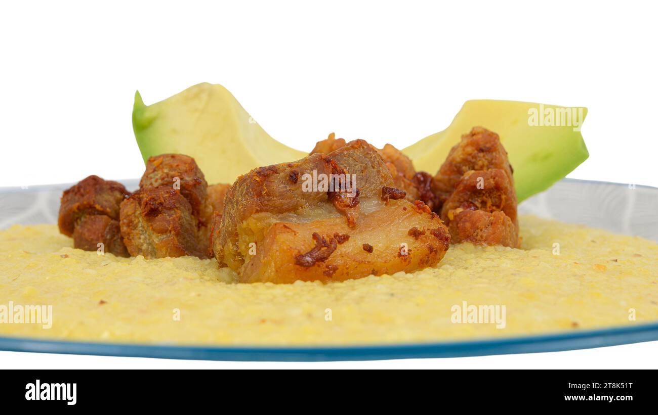 Cooked cornmeal in the Cuban style cuisine. Avocado and fried pork Stock Photo