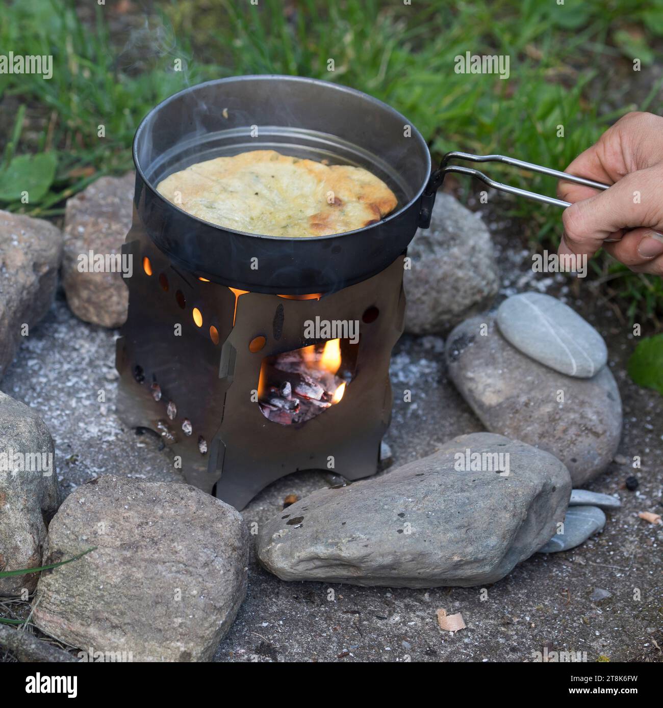 making of bannock, is baked on open fire, bread dough is formed and baken in a pan on a camp cooker, series picture 5/5 Stock Photo