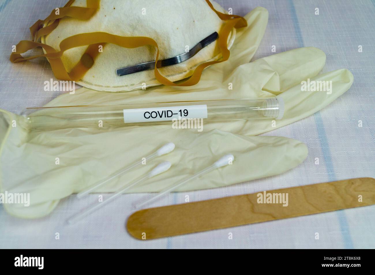 Corona test tubule, mask, latex glove, cotton swab and spatula Stock Photo