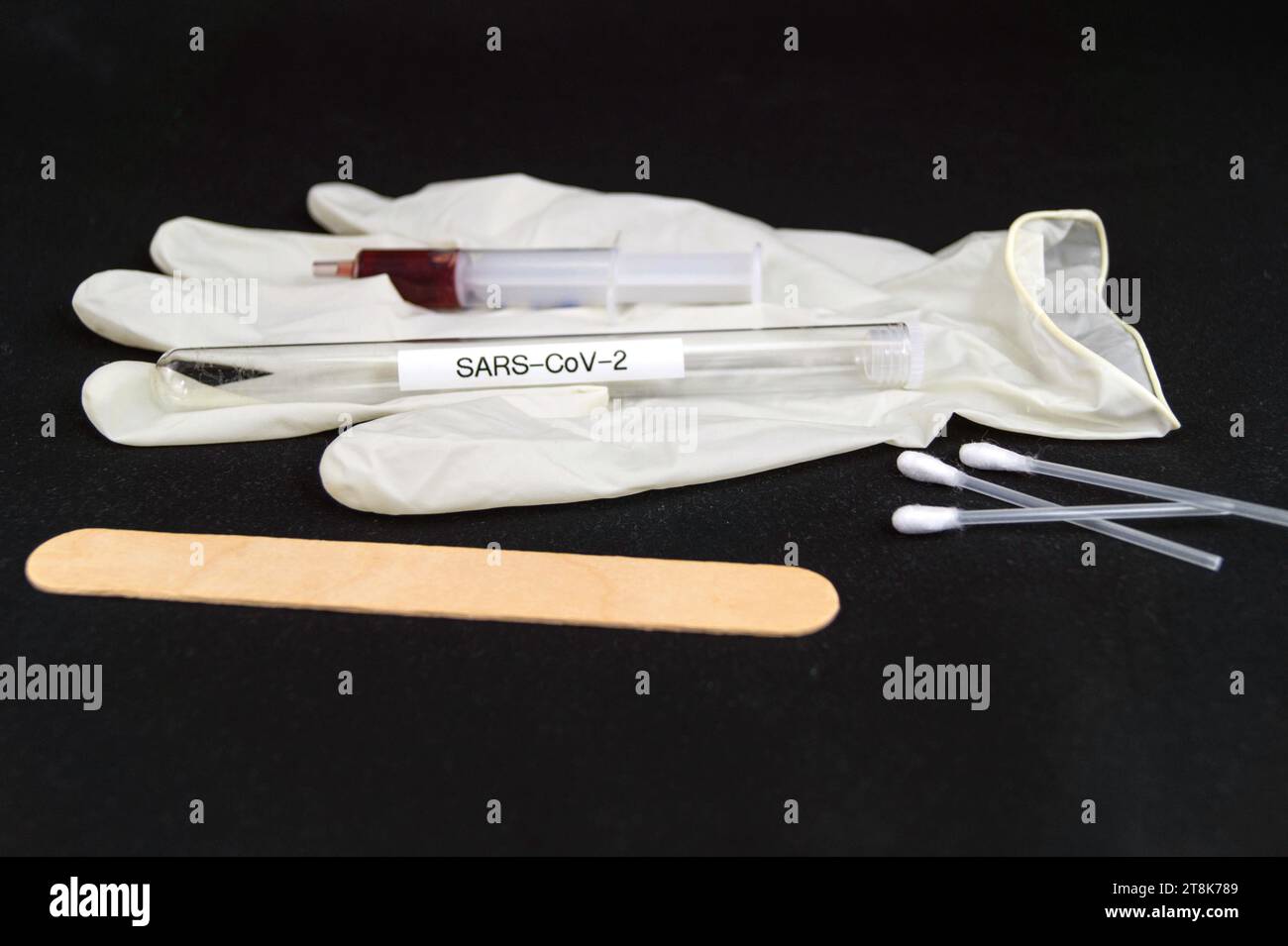 Corona test tubule, syringe, latex glove, cotton swab and spatula Stock Photo