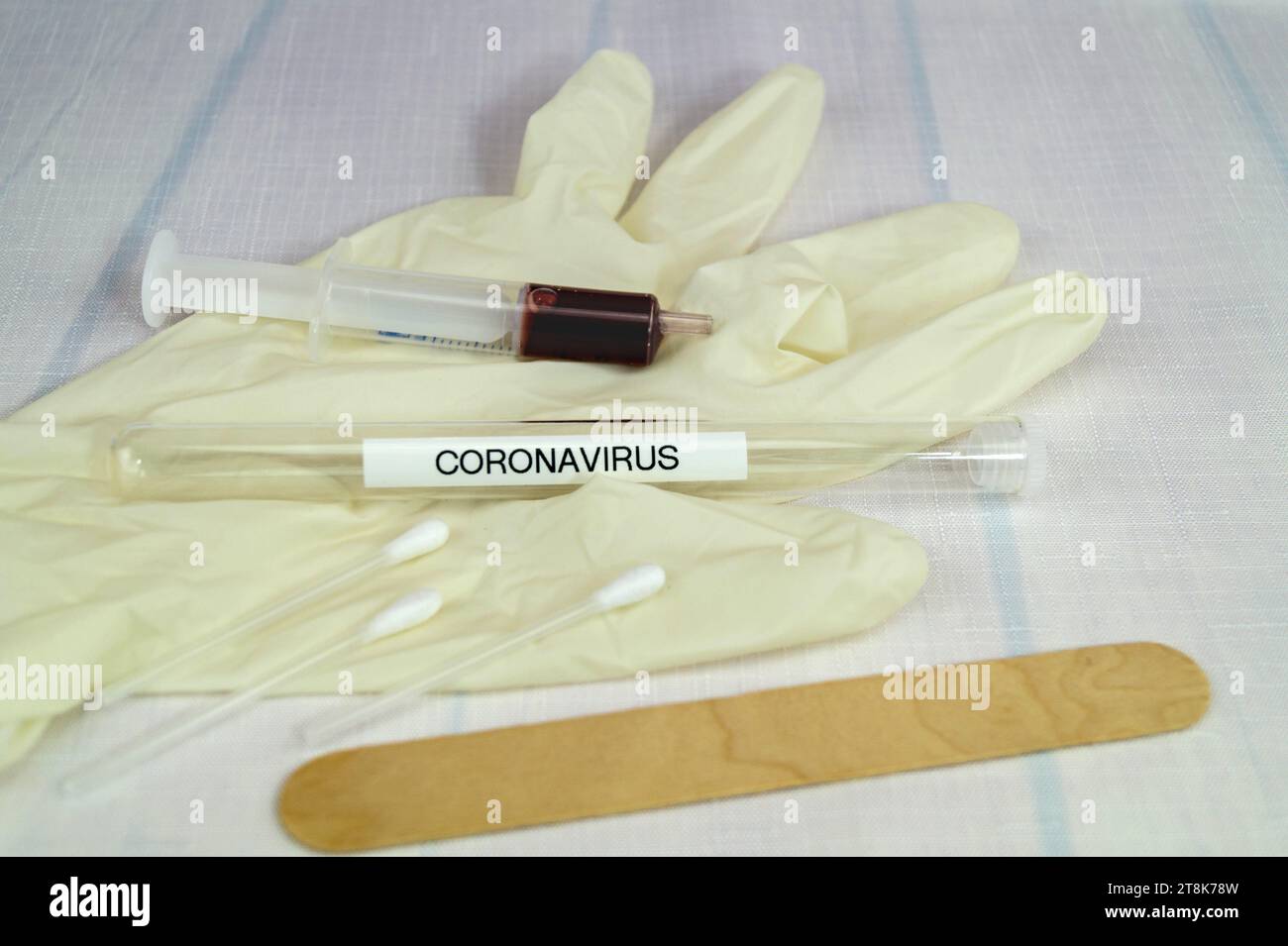 Corona test tubule, syringe, latex glove, cotton swab and spatula Stock Photo