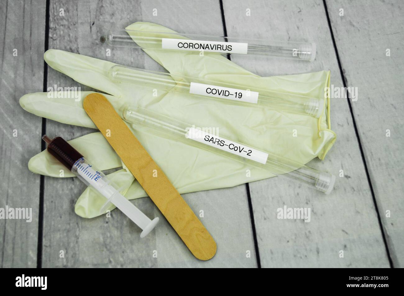 Corona test tubule, syringe, latex glove, cotton swab, and spatula Stock Photo
