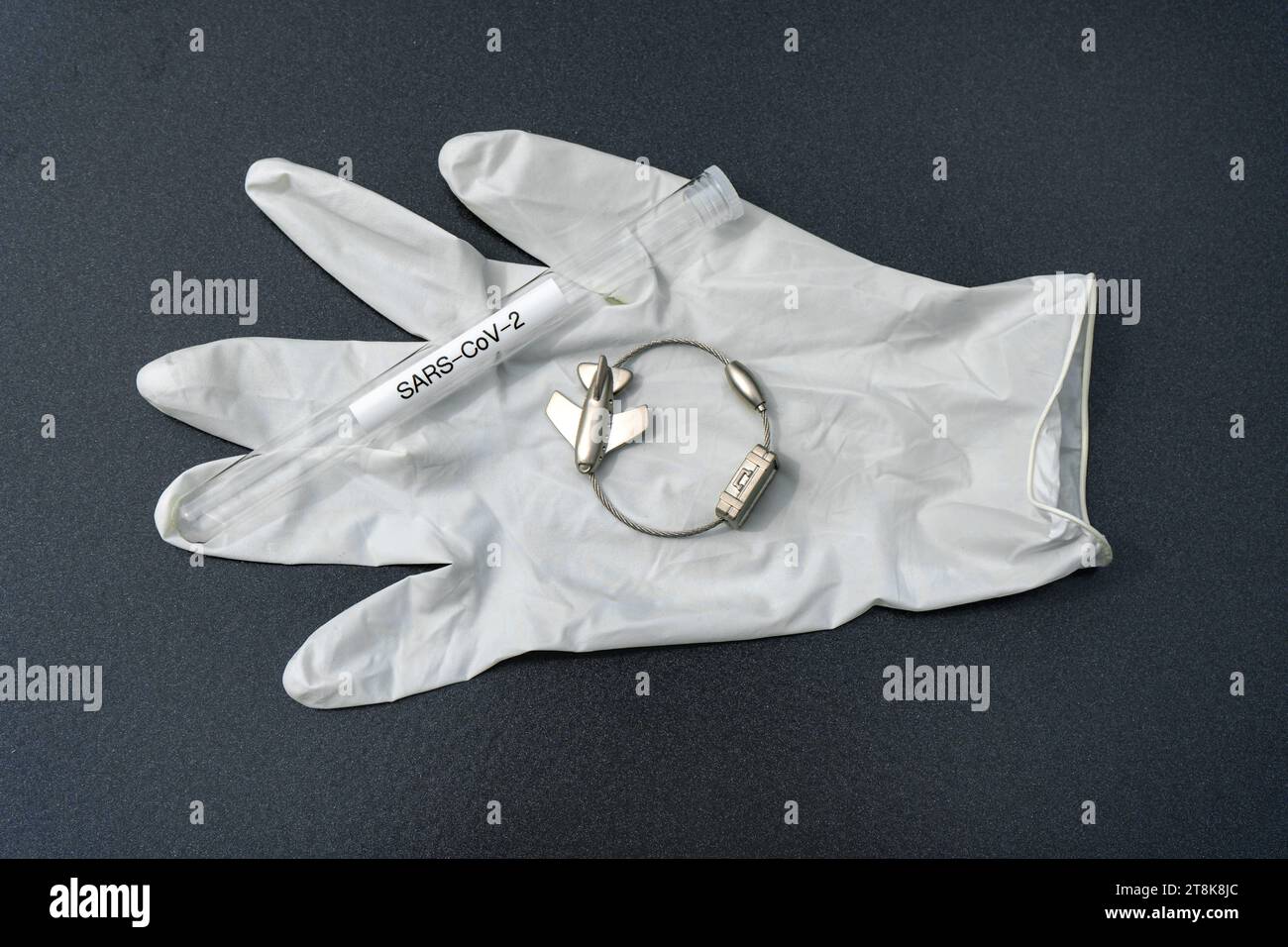 latex glove, test tubule, and luggage tag with plane, flight voyage