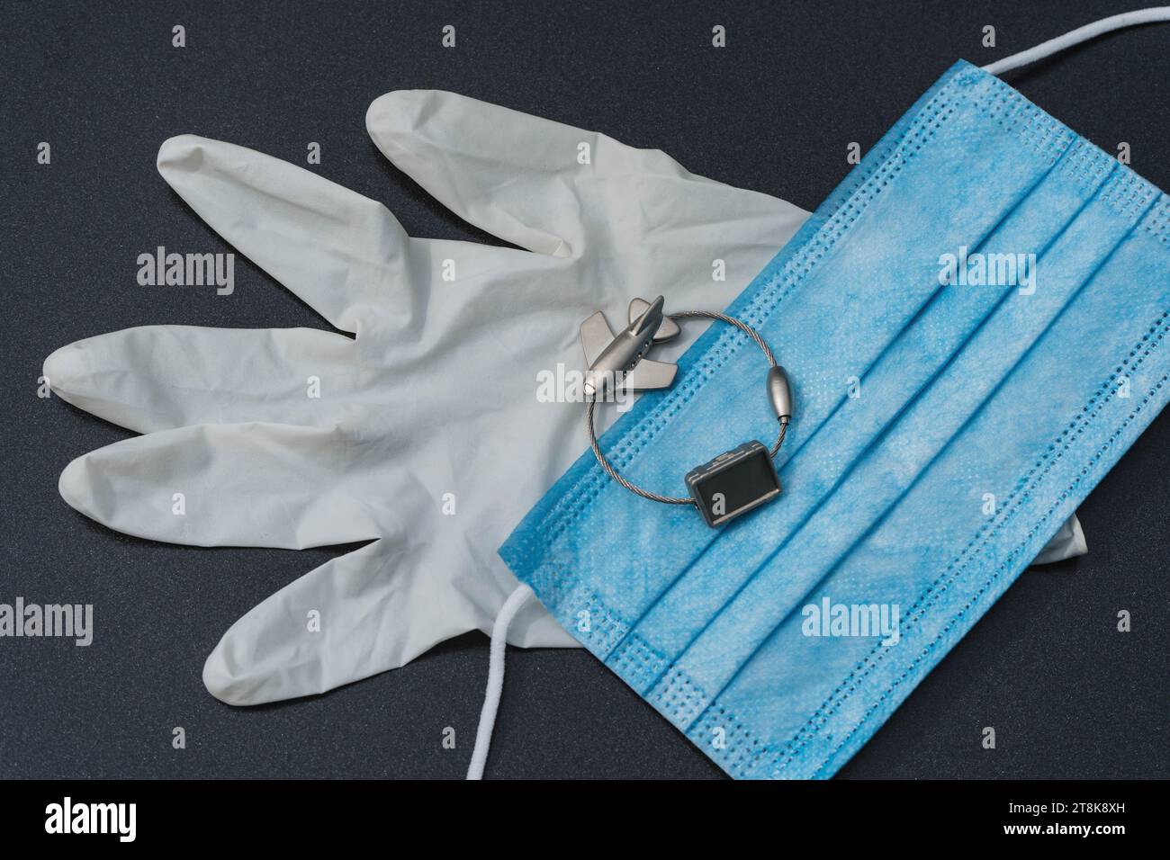 latex glove, mask, and luggage tag with plane, flight voyage under Corona conditions Stock Photo