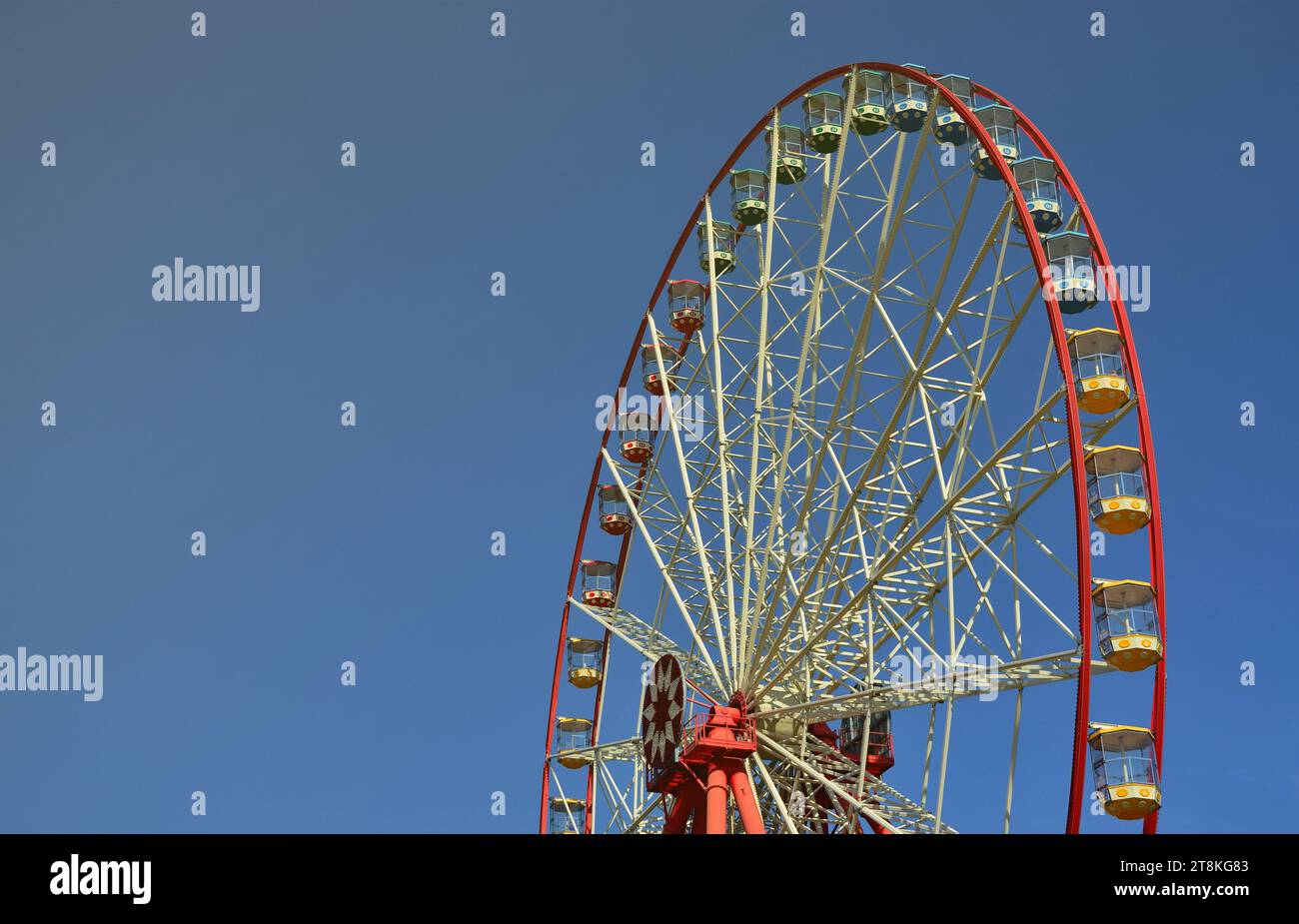 Big and modern multicolour ferris wheel on clean blue sky background ...