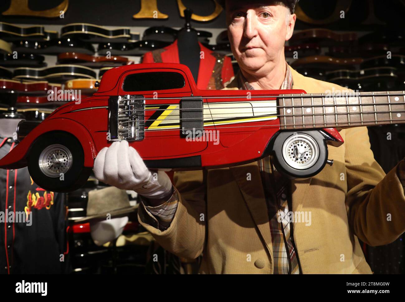 New York, New York, USA. 20th Nov, 2023. Executive Director/Co-Founder of Julien's Auctions Martin Nolan holds circa 1983, Wayne Charvel, Custom Eliminator Hot Rod car shaped bass guitar estimate 40k - 60k, seen at ''˜The Collection of Dusty Hill of ZZ Top' Julien's Auctions Press Preview at the Hard Rock Cafe New York in Times Square. Credit: ZUMA Press, Inc./Alamy Live News Stock Photo