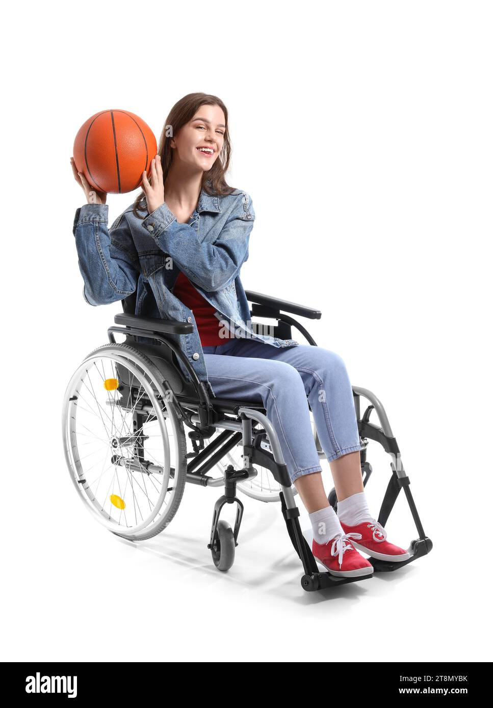 Young woman in wheelchair with ball on white background Stock Photo