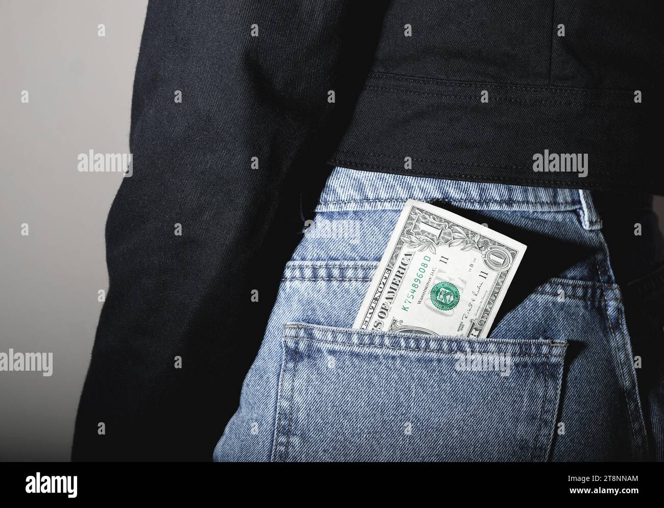 One dollar Bill Sticking Out Of A Pocket. The banknote is sharply contrasted Stock Photo