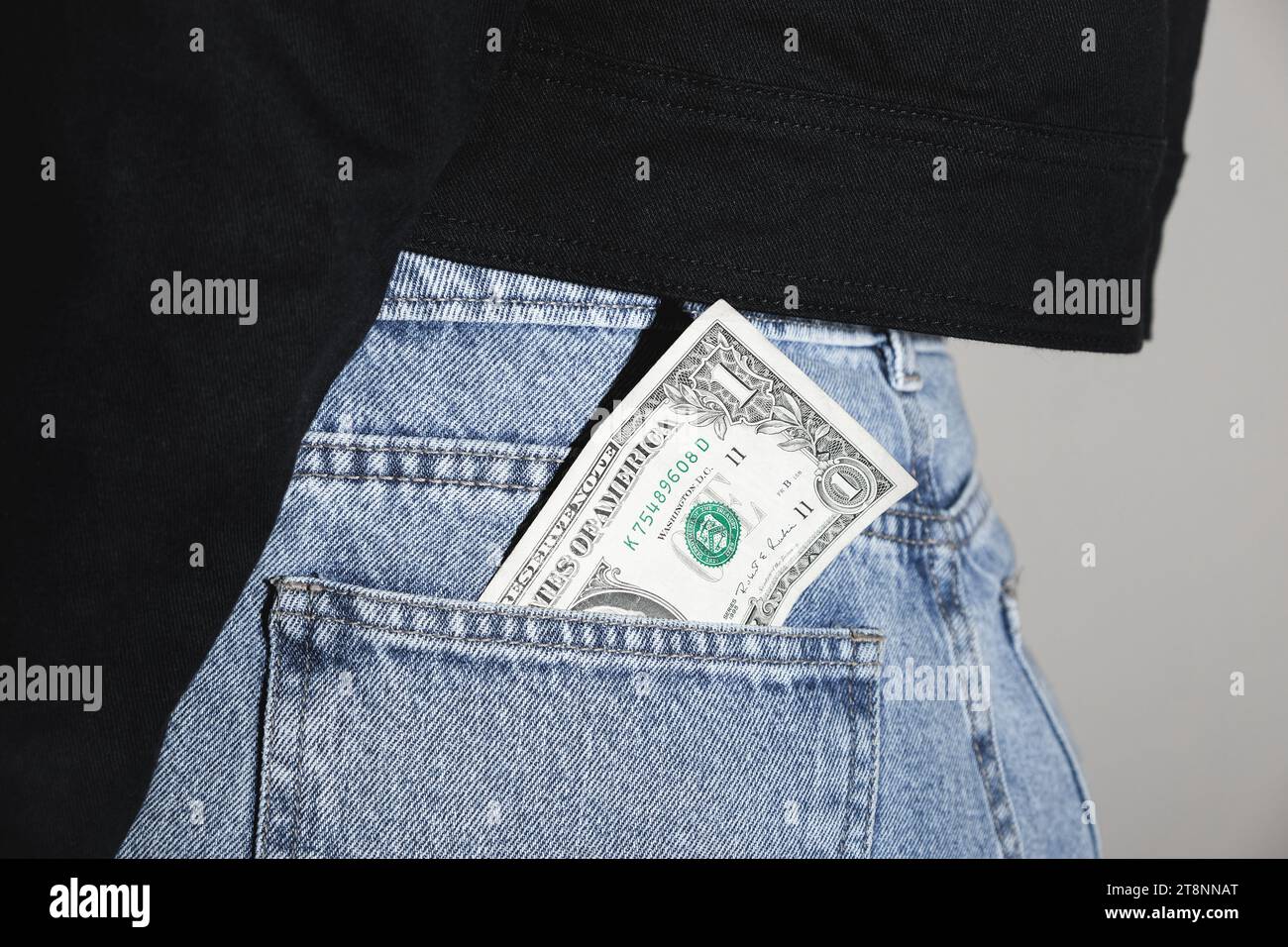 One Dollar Bill Sticking Out Of An Anonymous Person's Back Pocket Stock Photo