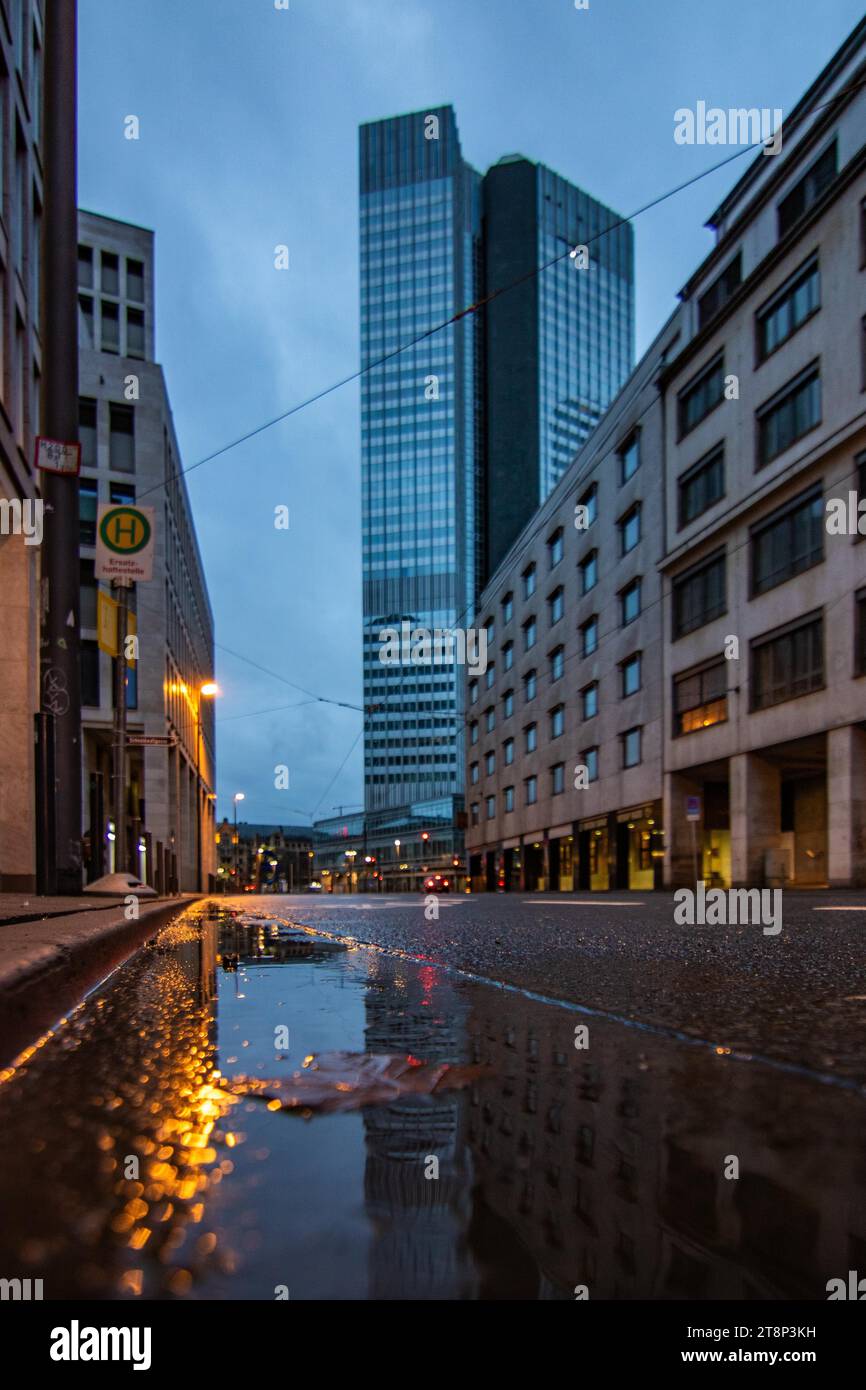 Reflection in a puddle between skyscrapers. Cityscape with modern office buildings and streets. Insurance companies and banks as a cityscape in Stock Photo