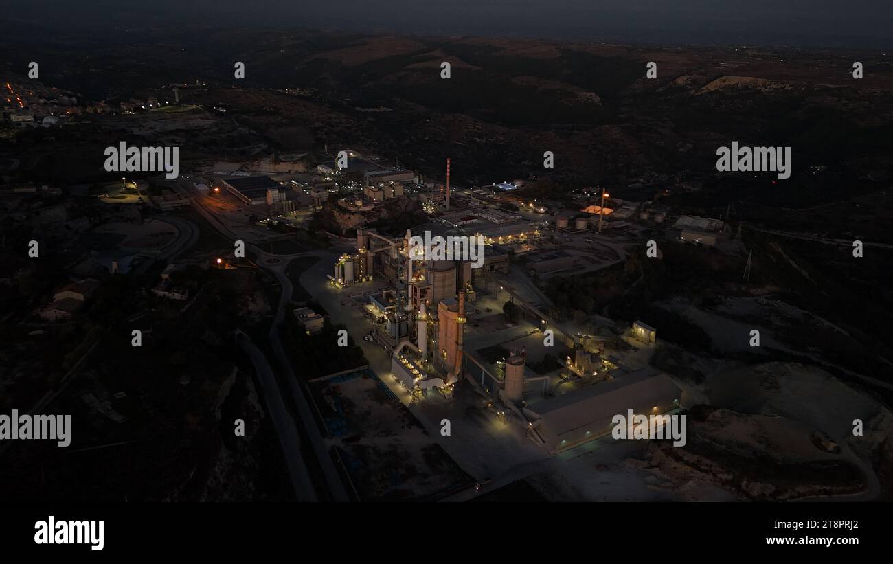 An aerial view of illuminated oil and gas industry facility at night ...