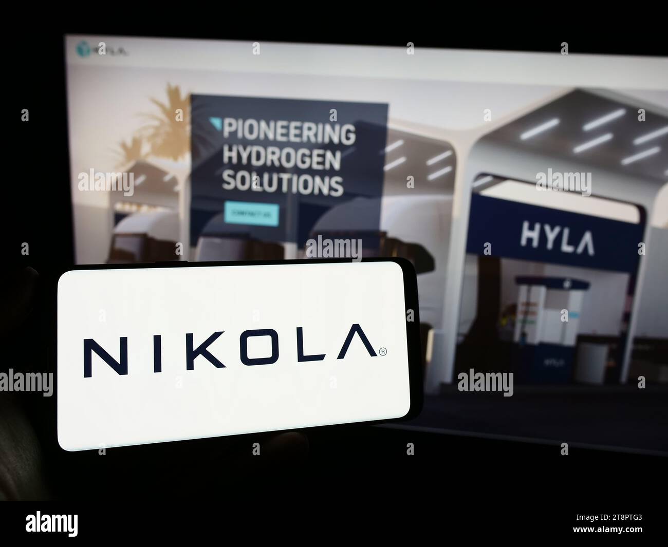 Person holding cellphone with logo of US electric vehicle company Nikola Corporation in front of business webpage. Focus on phone display. Stock Photo