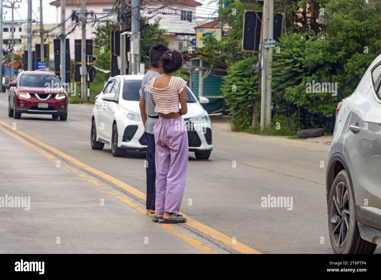 People stand in the middle of the road and wait to walk between moving