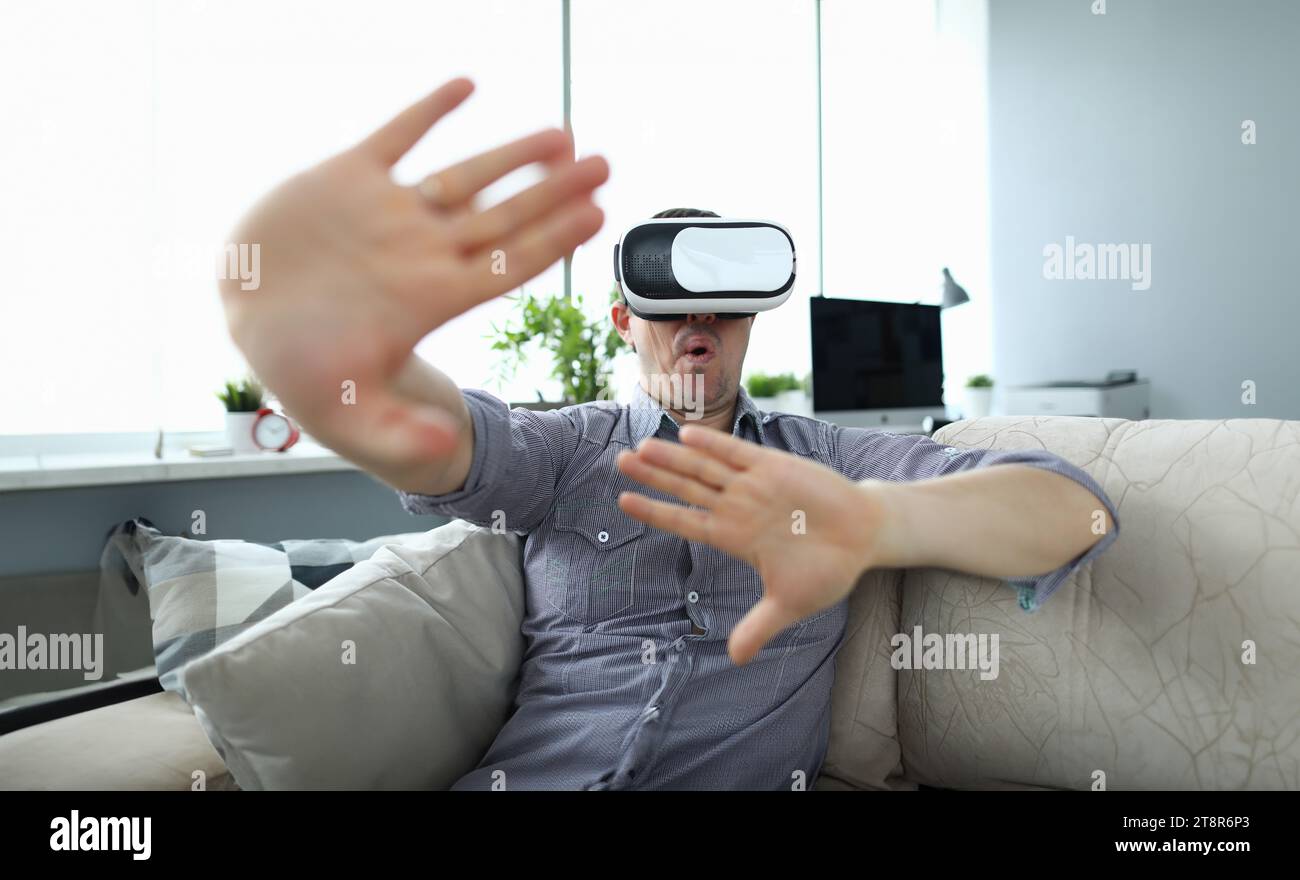 Man sits at home on the couch uses virtual reality Stock Photo