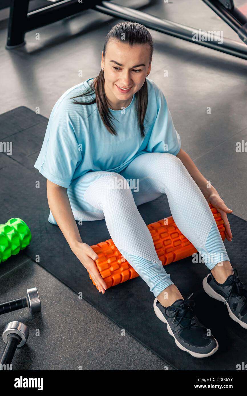 Sport woman using foam roller for muscle and fascia stretching foot ...