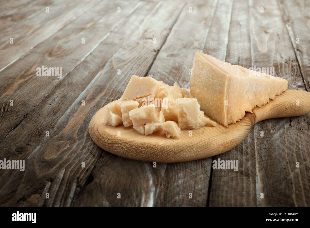 Parmesan cheese blocks on wooden board. Stock Photo